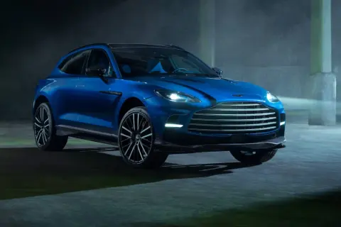 Niebieski Aston Martin DBX 707 lśni w półmroku, gotowy do podboju każdej drogi.