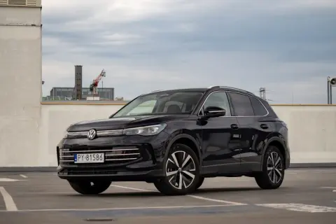 Czarny Volkswagen Tiguan 2020 na parkingu, z widocznym fragmentem miasta w tle.