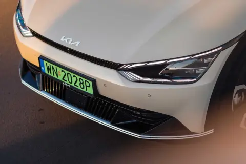 Nowy Kia z zieloną tablicą rejestracyjną WN 2028P. Zbliżenie na przednią część samochodu elektrycznego.