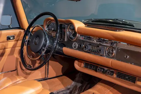 Wnętrze klasycznego **Mercedes Pagoda** z brązową skórzaną tapicerką, chromowanymi detalami i radiem Becker.