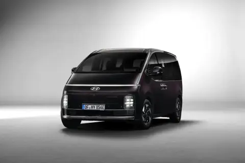 Ciemny Hyundai Staria z charakterystycznym pasem świateł LED na przodzie, gotowy na rodzinne podróże.