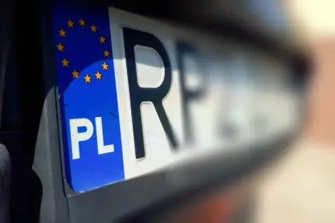 Zbliżenie na polską tablicę rejestracyjną z symbolem Unii Europejskiej. Litery "PL" i fragment kolejnych liter wskazują na bbi rejestracja.