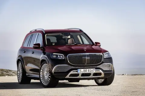 Luksusowy, bordowy GLS Maybach z chromowanymi felgami stoi na pustkowiu, gotowy na każdą podróż.