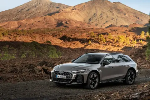 Szary Audi allroad na tle wulkanicznego krajobrazu z górami w tle.