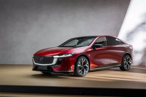 Elegancka, czerwona Mazda 6e prezentuje się na drewnianej scenie.