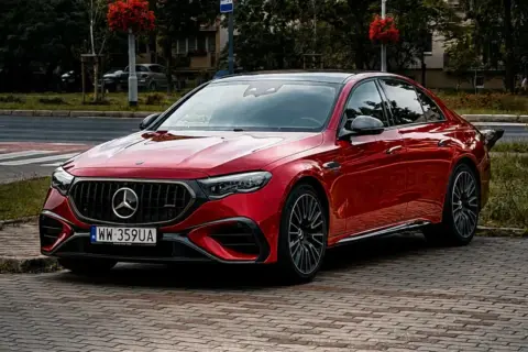 Błyszczący czerwony Mercedes-Benz EQC 400 4MATIC, model e53 amg, zaparkowany na bruku.