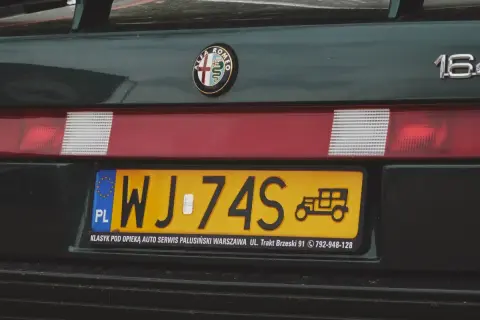 Nowe tablice rejestracyjne z symbolem starego auta na zielonym Alfa Romeo 164.