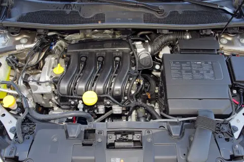 Silnik benzynowy Renault Megane 3, z widocznymi przewodami, cewkami zapłonowymi i żółtymi korkami.