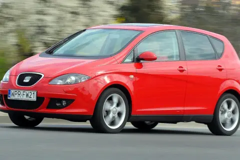 Czerwony Seat Altea 1.6 benzyna w ruchu, z rozmytym tłem.