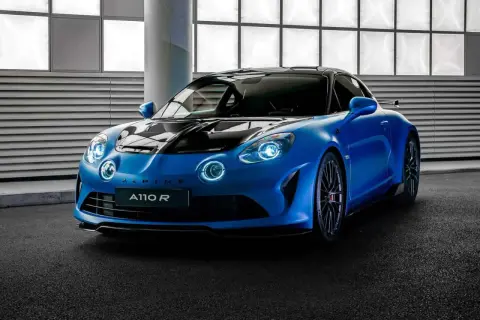 Niebieski Alpine A110 R z czarną maską i dachem, gotowy do jazdy po torze.