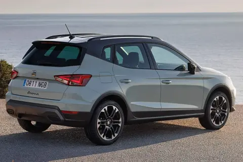Szary Seat Arona z czarnym dachem zaparkowany przy morzu. Idealny na wakacyjne wycieczki.