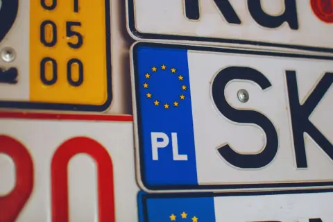 Kolekcja tablic rejestracyjnych, w tym polska z symbolem UE i oznaczeniem PL.