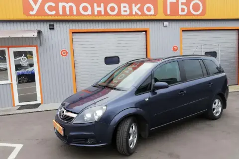 Opel Zafira 1.6 benzyna opinie: rodzinny van przed budynkiem z napisem "Установка ГБО".