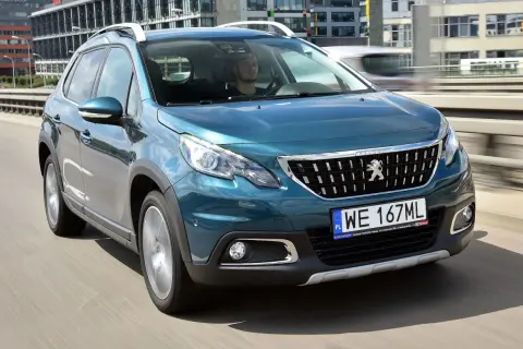 Turkusowy Peugeot 2008 na drodze. Kierowca w środku. Wiele pozytywnych peugeot 2008 opinie o tym modelu.
