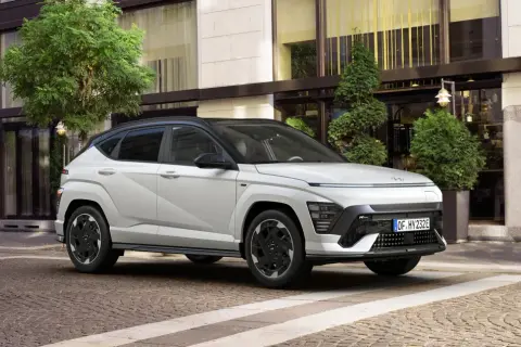 Biały Hyundai Kona N Line na tle eleganckiego budynku. Sprawdź aktualną hyundai kona cena i wybierz swój wymarzony model.
