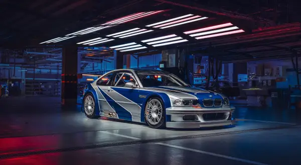 Wyścigowe e46 BMW M3 GTR w garażu, z niebiesko-srebrnym malowaniem, gotowe do akcji.