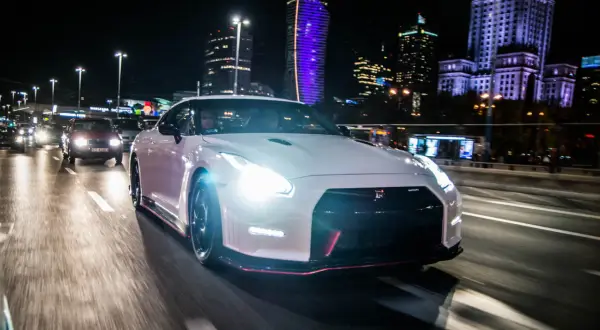 Biały Nissan GTR na nocnej ulicy Warszawy. Zastanawiasz się nad nissan gtr cena?