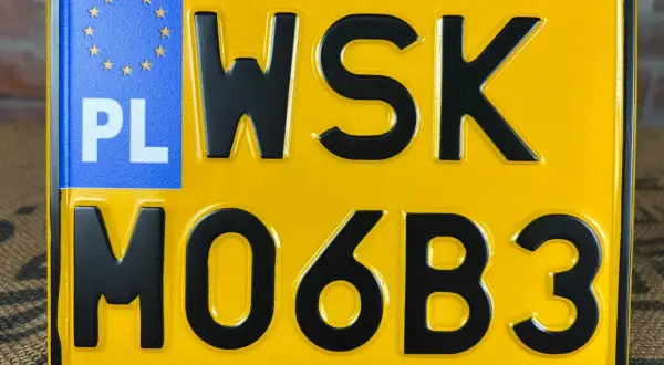 Żółta tablica rejestracyjna z literami WSK i cyframi MO6B3. PL oznacza Polskę.