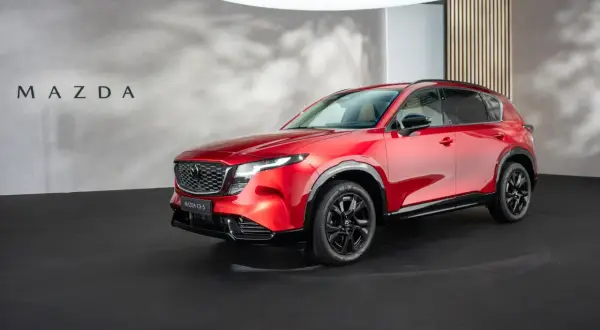 Błyszcząca, czerwona, nowa Mazda CX-5 prezentowana na czarnej scenie.