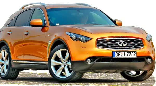 Pomarańczowy **Infiniti samochód** z chromowanymi detalami i felgami stoi na tle białej przestrzeni.