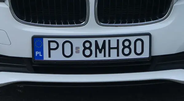 Białe BMW z tablicą rejestracyjną PO 8MH80.