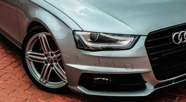 Srebrne Audi z reflektorami bixenon, które zapewniają doskonałą widoczność dzięki technologii xenon.