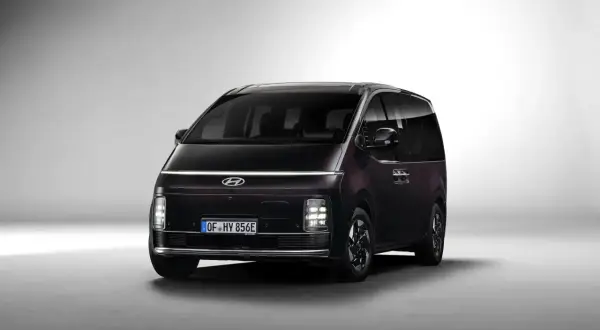 Ciemny Hyundai Staria z charakterystycznym pasem świateł LED na przodzie, gotowy na rodzinne podróże.