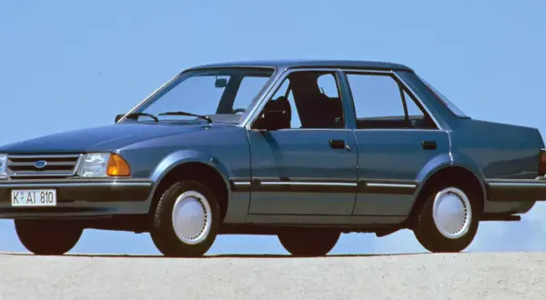 Niebieski Ford Orion z lat 80. na tle błękitnego nieba. Klasyk z przeszłości, który wciąż budzi nostalgię.