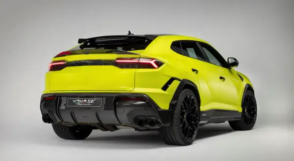 Jaskrawożółty Lambo Urus z czarnymi detalami i felgami, prezentujący sportowy tył z dyfuzorem i podwójnymi końcówkami wydechu.