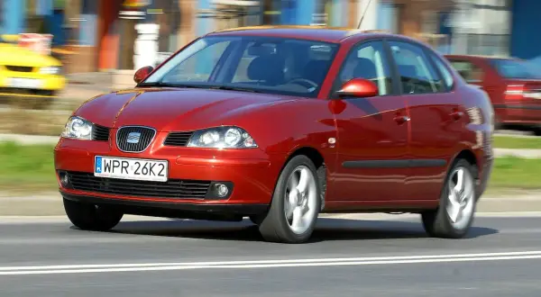 Czerwony Seat Cordoba 1.4 w ruchu ulicznym, z rozmytym tłem sugerującym prędkość.