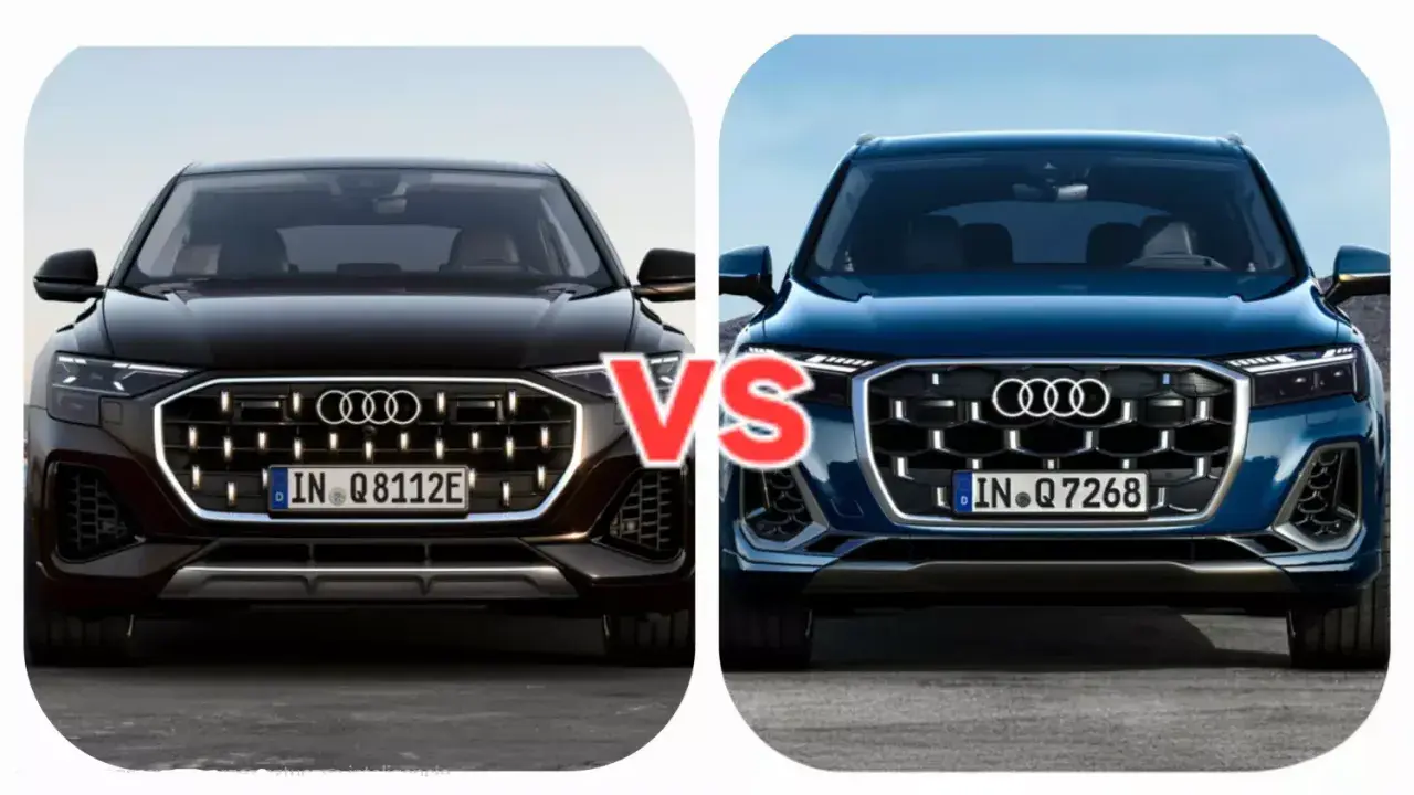 Dwa nowe Audi Q7 w zbliżeniu, czarne i granatowe, z napisem "VS" pośrodku.