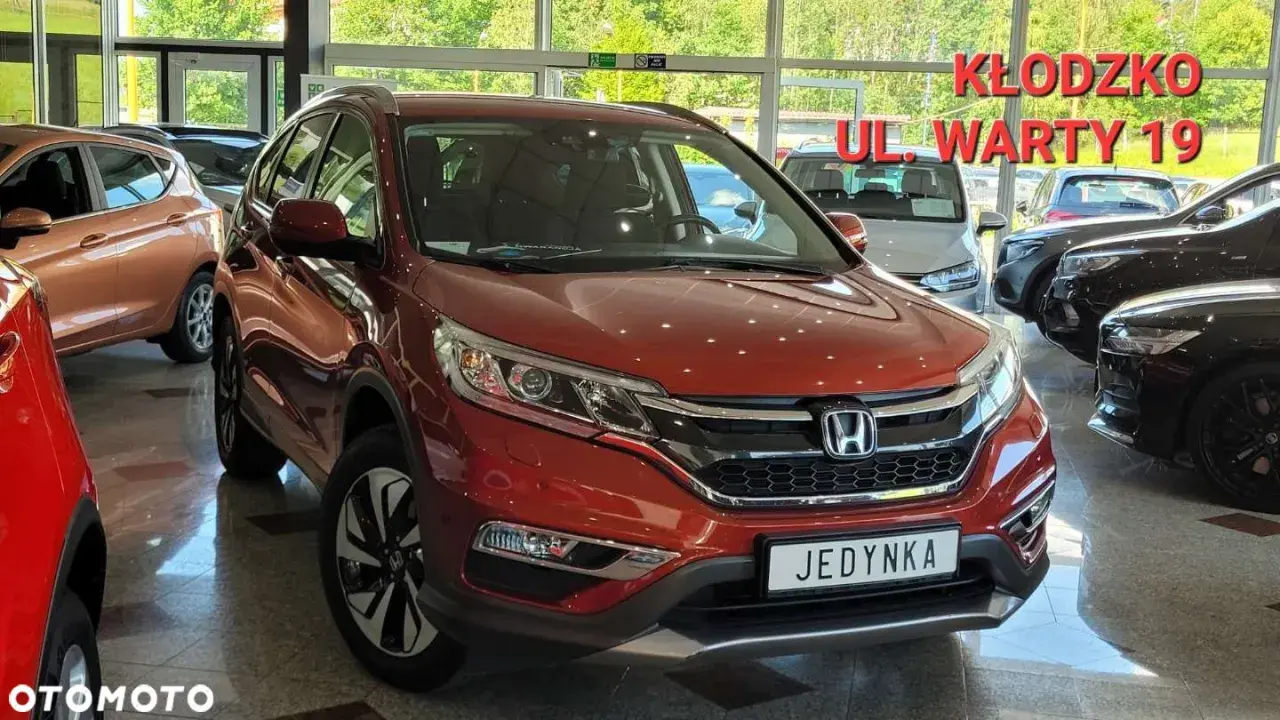 Czerwona Honda CR-V 4 generacji w salonie samochodowym.