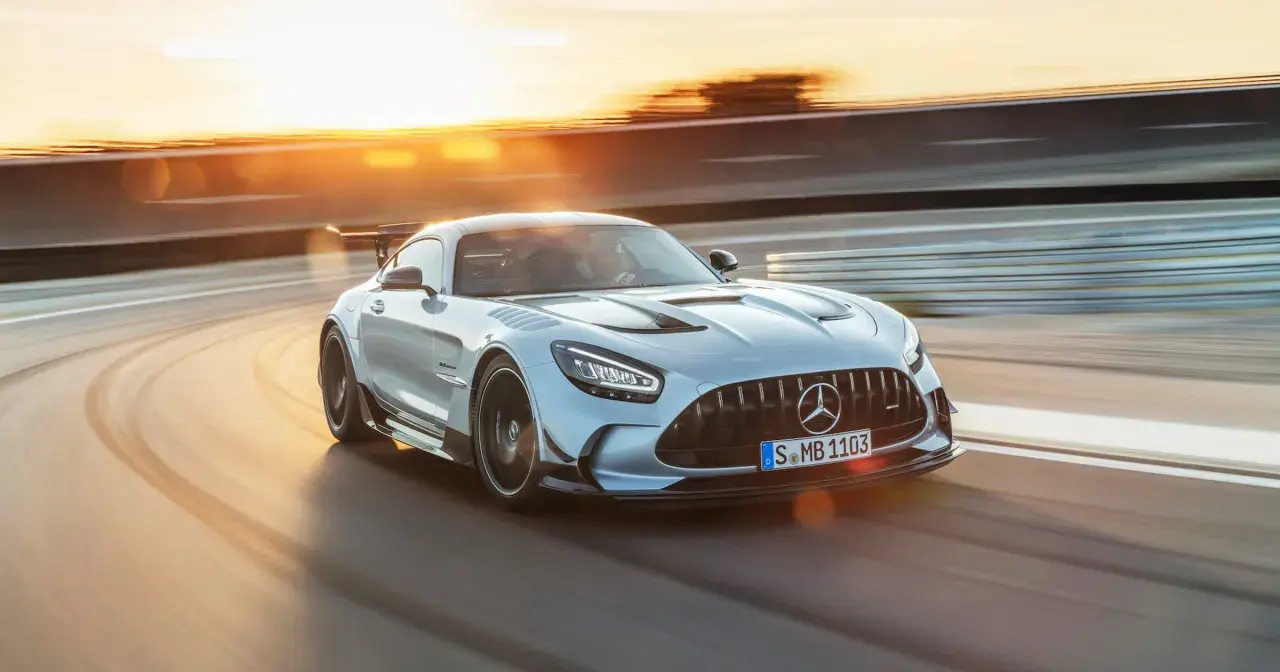 Srebrny Mercedes-AMG GT Black Series na torze wyścigowym, w promieniach zachodzącego słońca.
