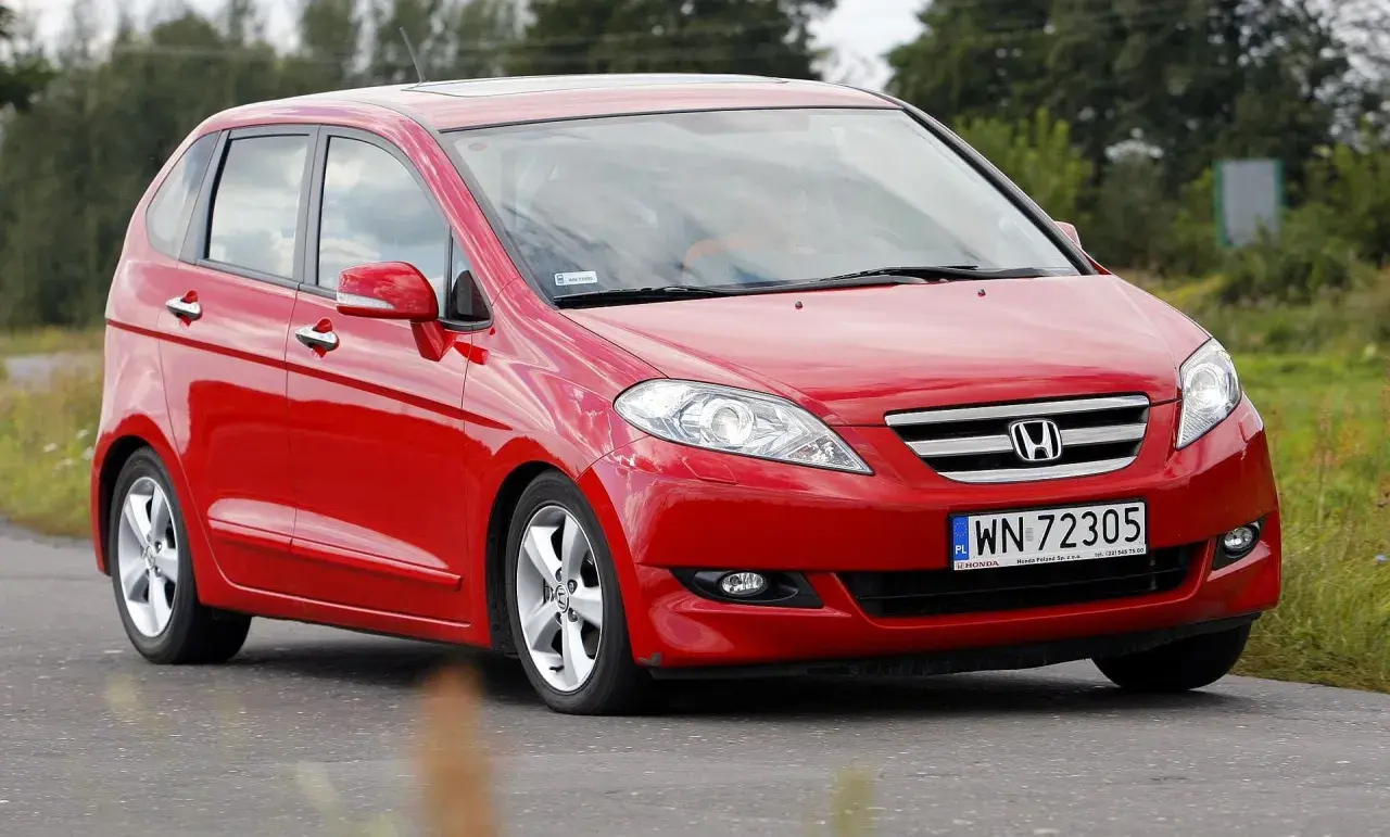 Czerwona Honda FR-V na drodze, z widocznym logo i tablicą rejestracyjną.