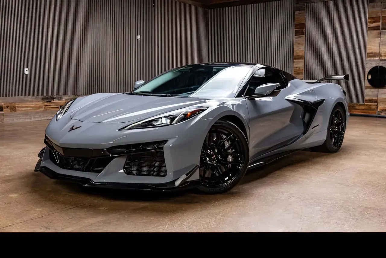 Szary Chevrolet Corvette C8 z czarnymi felgami i spojlerem, gotowy do jazdy.