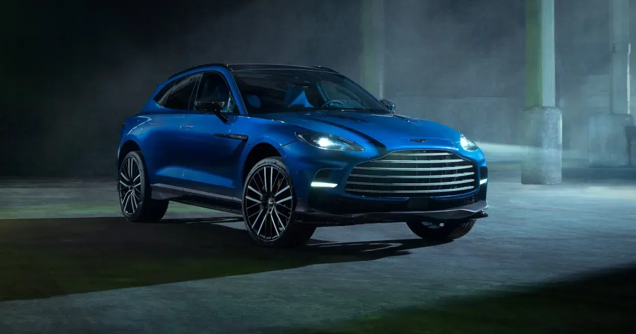 Niebieski Aston Martin DBX 707 lśni w półmroku, gotowy do podboju każdej drogi.