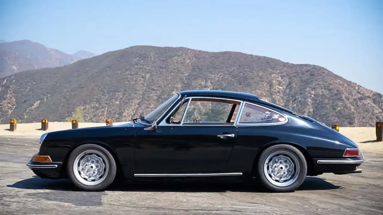 Klasyczny czarny Porsche 912 na tle górskich krajobrazów.
