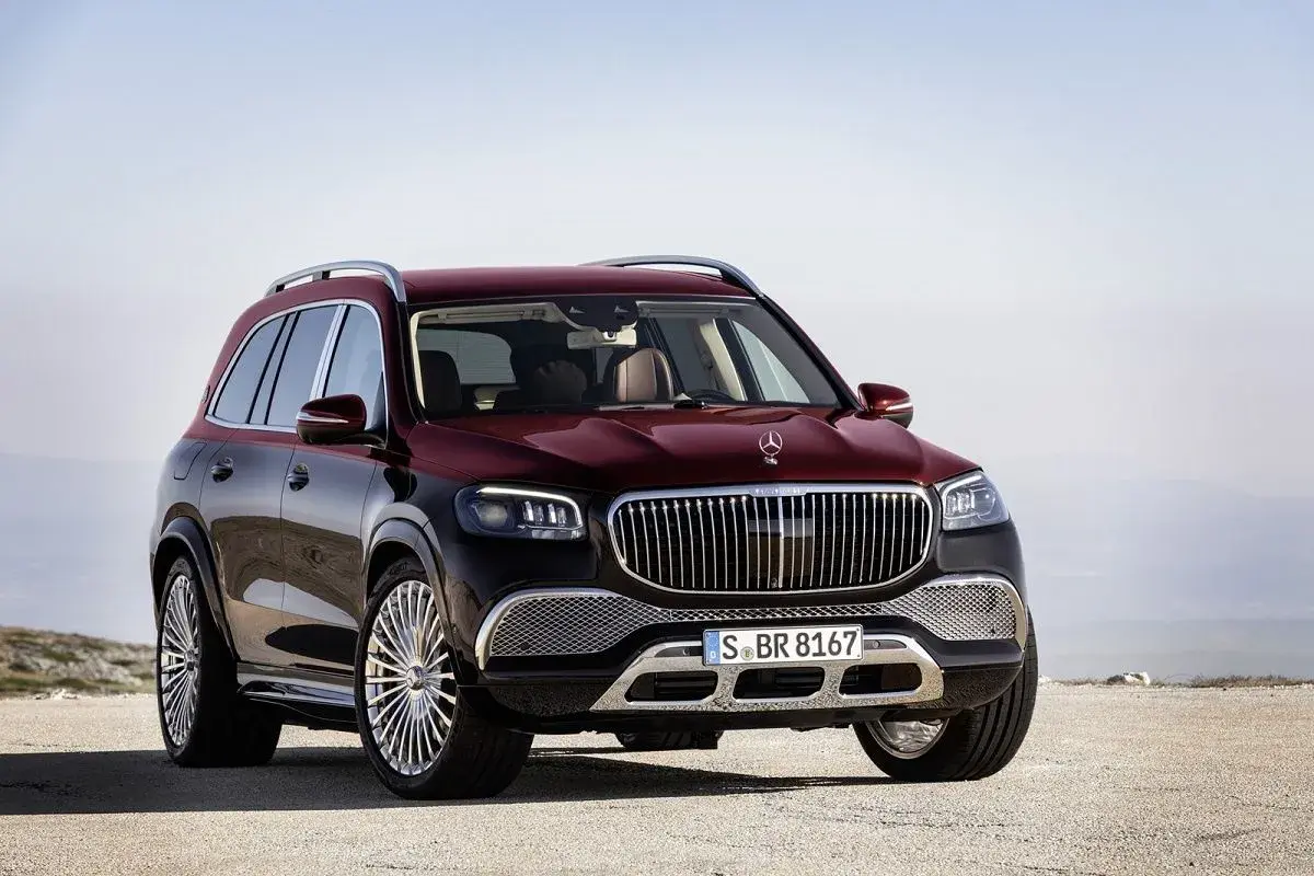 Luksusowy, bordowy GLS Maybach z chromowanymi felgami stoi na pustkowiu, gotowy na każdą podróż.