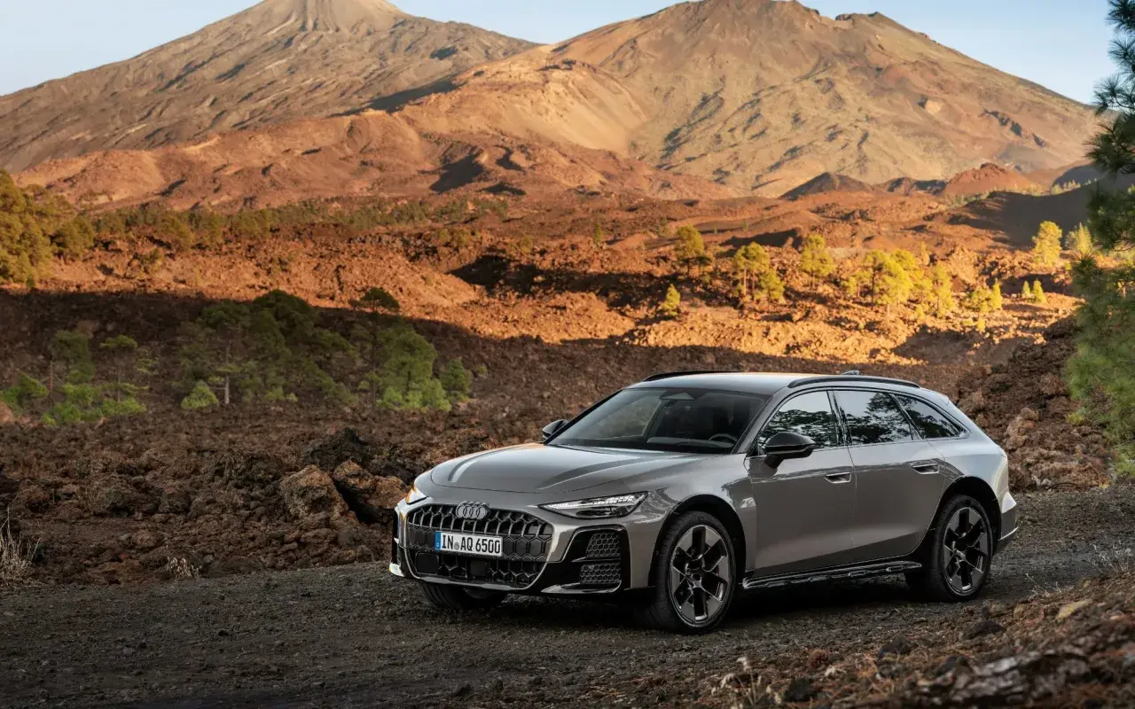 Szary Audi allroad na tle wulkanicznego krajobrazu z górami w tle.