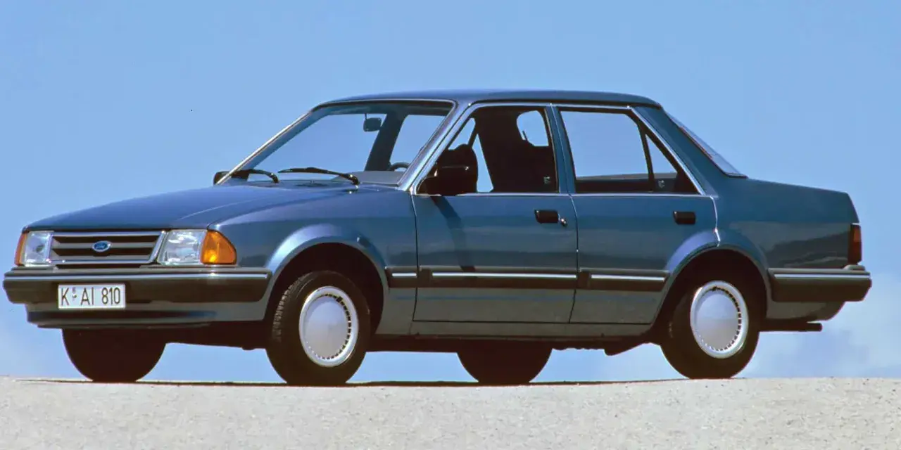 Niebieski Ford Orion z lat 80. na tle błękitnego nieba. Klasyk z przeszłości, który wciąż budzi nostalgię.