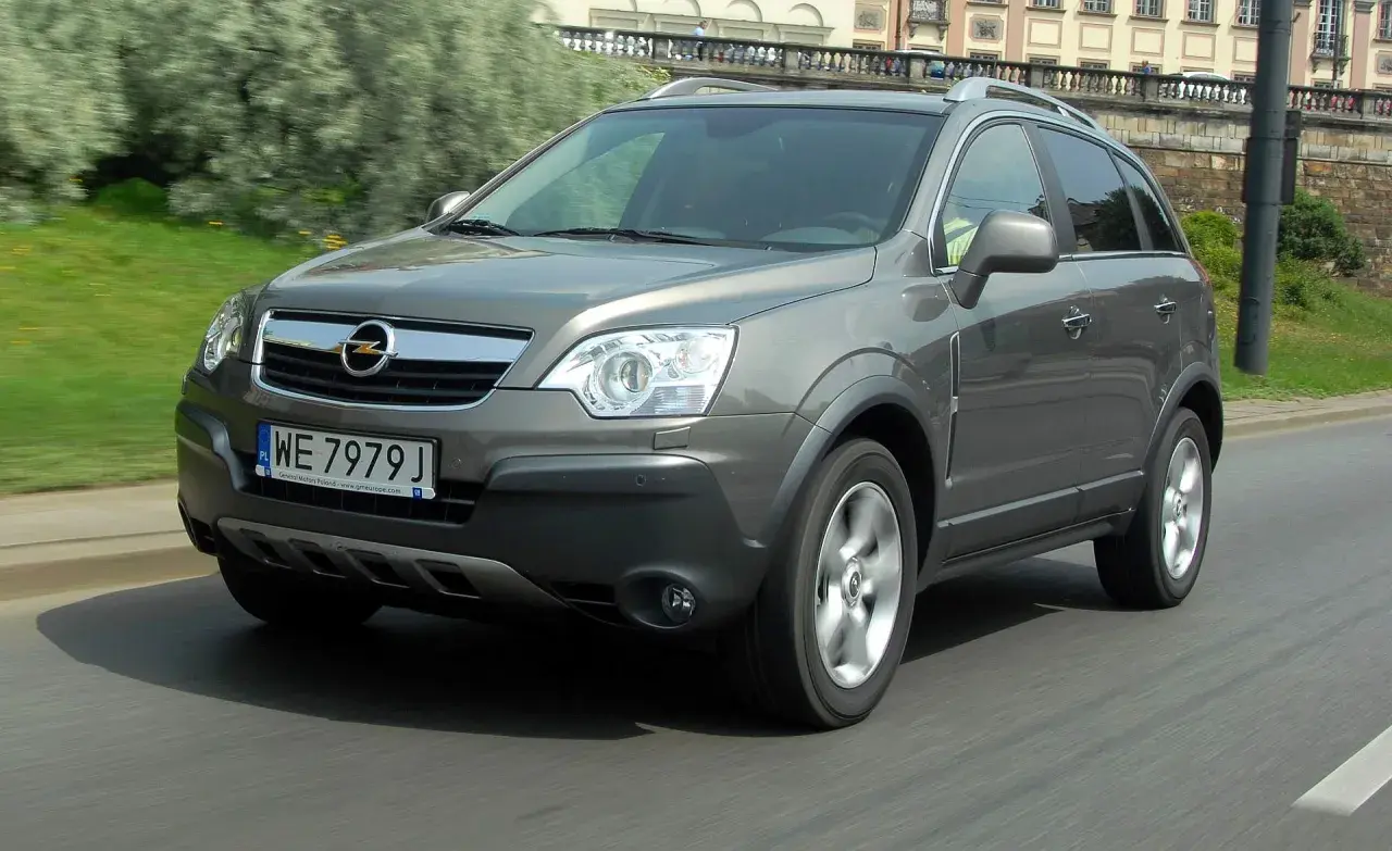 Szary Opel Antara w ruchu miejskim. Kierowca szuka opinii o tym modelu, by podjąć decyzję o zakupie.