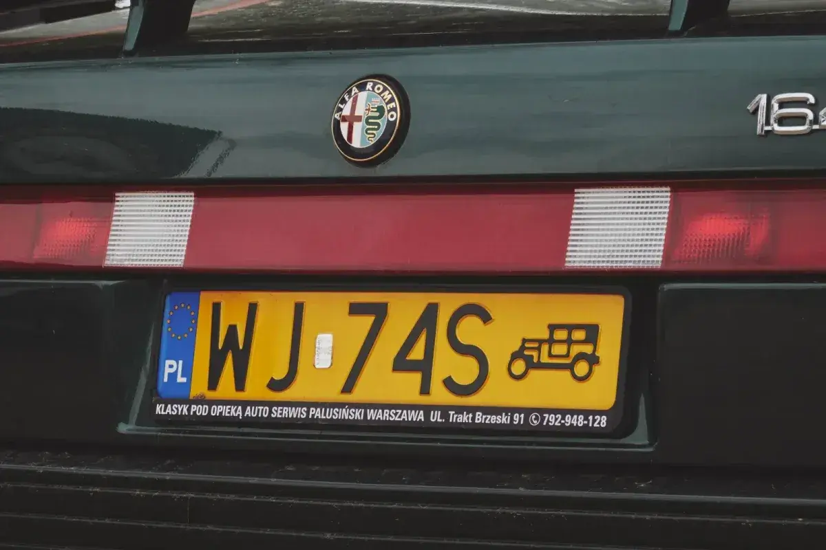 Nowe tablice rejestracyjne z symbolem starego auta na zielonym Alfa Romeo 164.