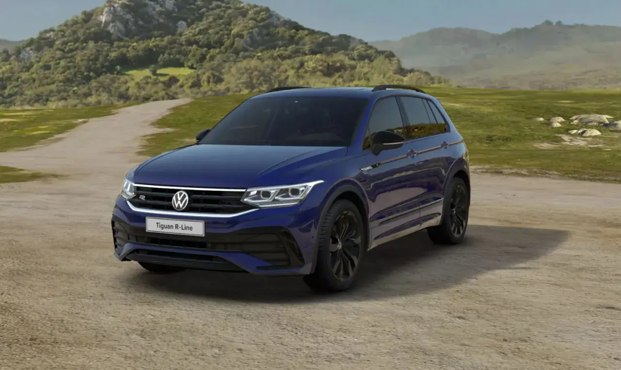 Niebieski Volkswagen Tiguan R-Line na tle krajobrazu. Wiele osób szuka volkswagen tiguan opinie przed zakupem.