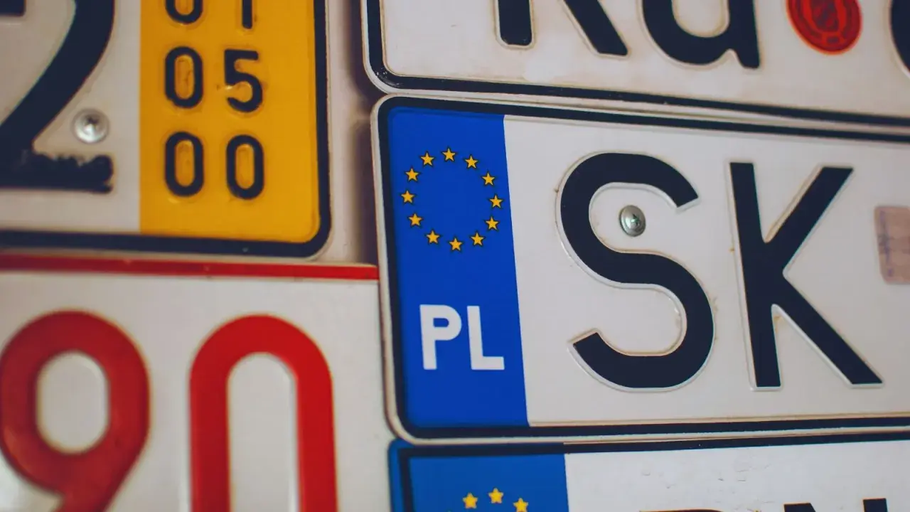 Kolekcja tablic rejestracyjnych, w tym polska z symbolem UE i oznaczeniem PL.