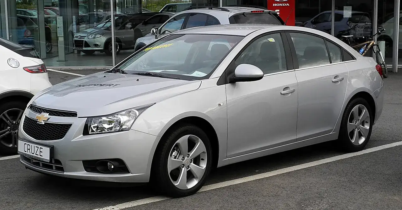 Srebrny Chevrolet Cruze na parkingu. Wiele osób szuka chevrolet cruze opinie przed zakupem.