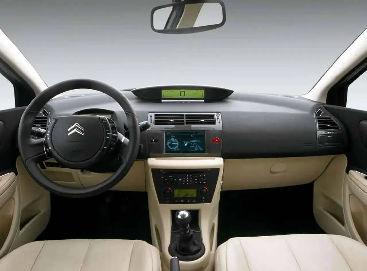 Wnętrze Citroen C4 2008 z kierownicą, cyfrowym wyświetlaczem i ekranem nawigacji.
