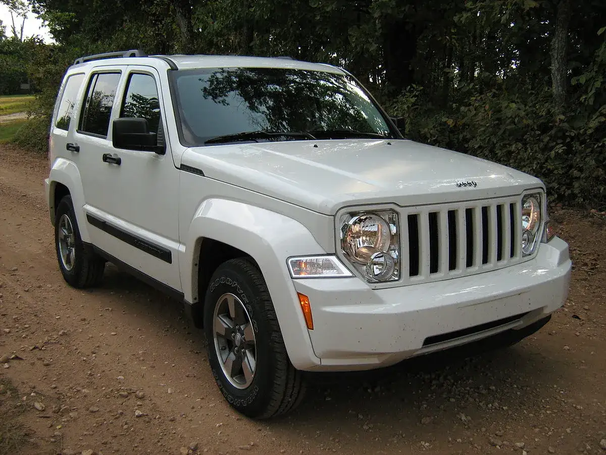 Biały Jeep Liberty 3.7 na drodze leśnej. Wiele osób szuka jeep liberty 3.7 opinie przed zakupem.