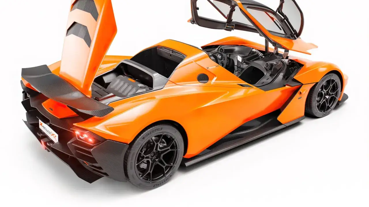Pomarańczowy KTM X-Bow z otwartymi drzwiami i maską, odsłaniający wnętrze i silnik. Wyścigowy wygląd z karbonowymi elementami.
