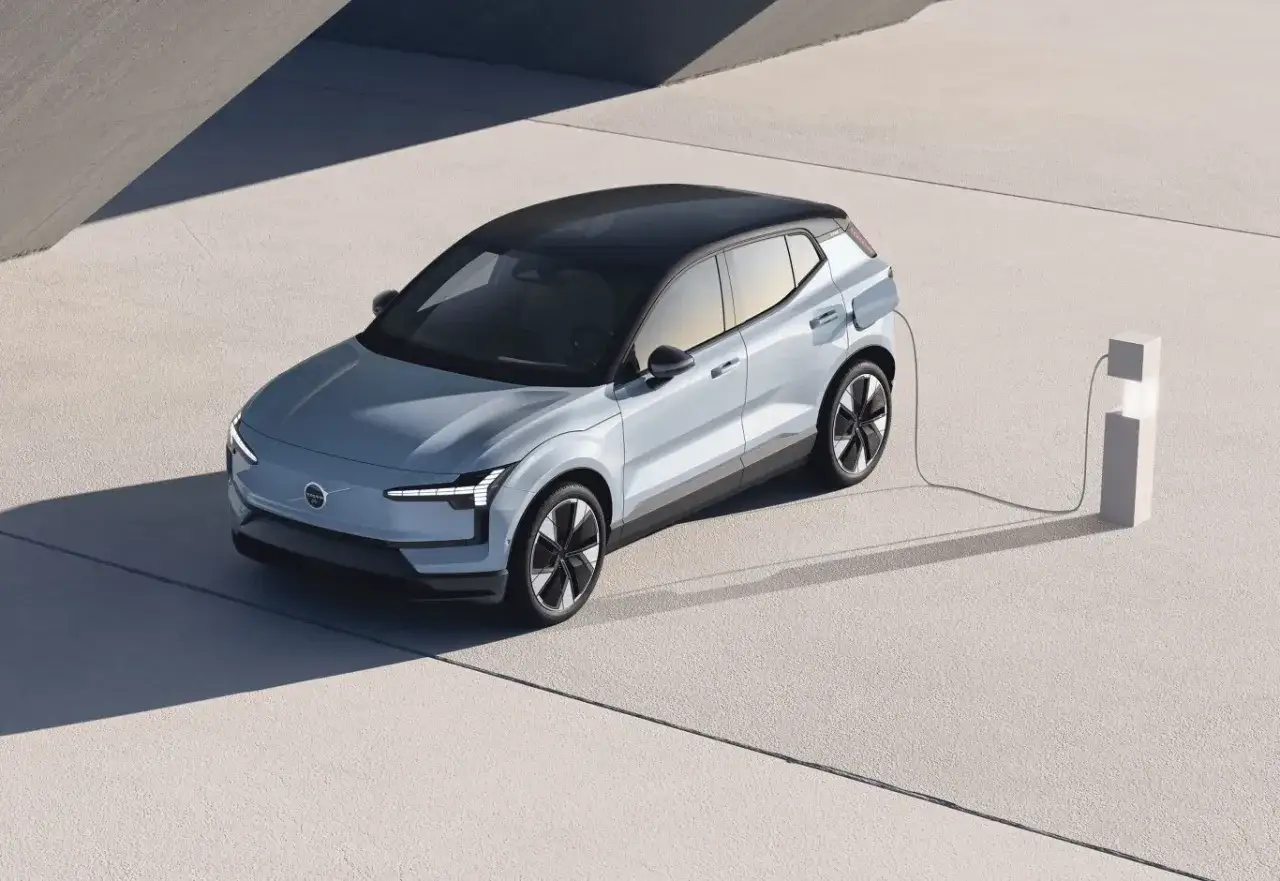 Nowoczesne Volvo EX30, ładowane przy minimalistycznej stacji.