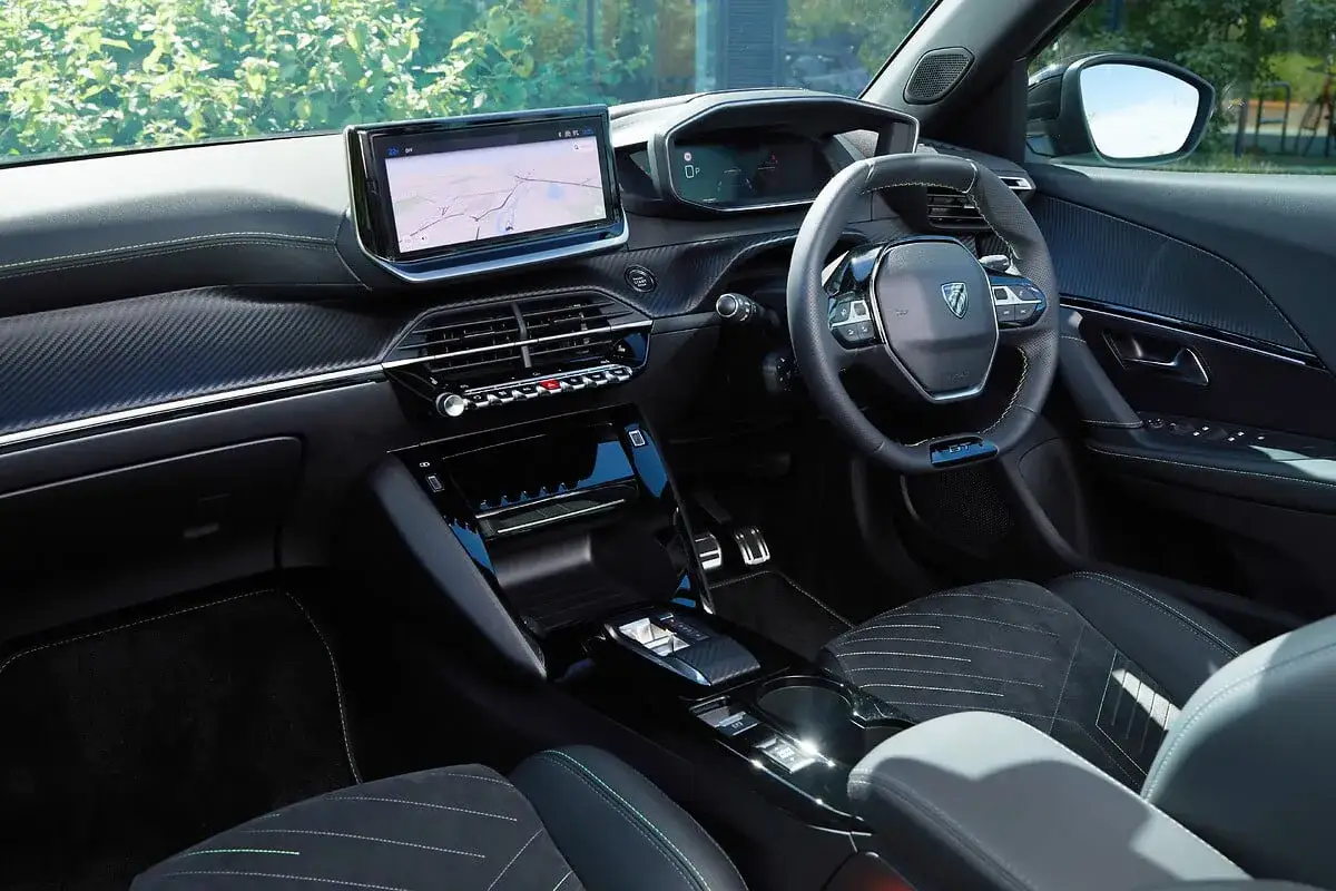 Wnętrze Peugeot 2008 GT: nowoczesny kokpit z ekranem nawigacji, cyfrowymi zegarami i sportową kierownicą.